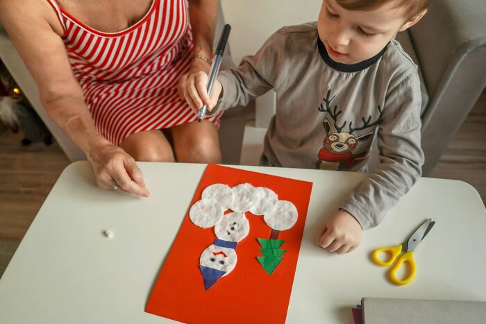 Child and adult crafting a Christmas-themed project, illustrating practical tips and tricks parents share with others.
