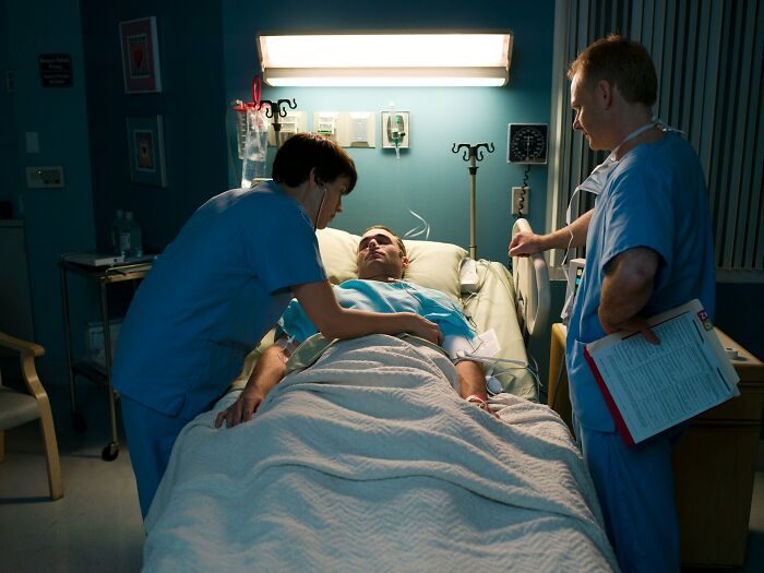 Two medical professionals attending to a patient in a hospital bed, illustrating unexpected and bizarre ways people passed away.