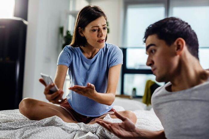 A young couple in a tense conversation, indicating signs of a future breakup during a wedding guest story.