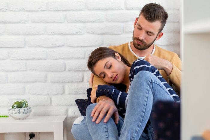 Young couple showing affection on couch, illustrating moments of being a good person facing total betrayal and shock.