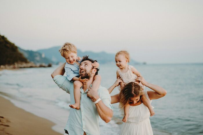 Family enjoying joyful time on the beach, showing resilience and happiness after dealing with horrible bullies in life.