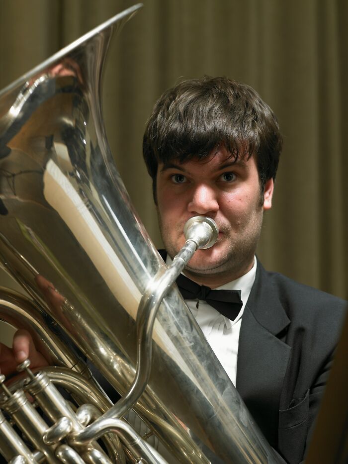 Man in a tuxedo playing a shiny silver tuba, one of the unusual TSA confiscated items travelers tried to bring.