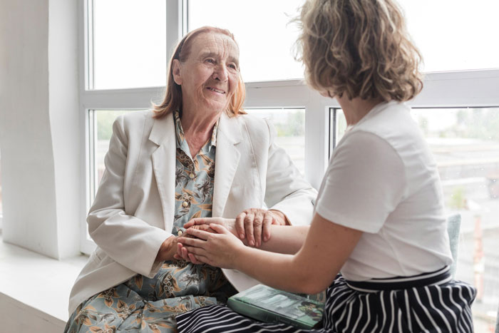 Elderly woman and younger woman holding hands, illustrating family conflict and nibling revenge leading to bankruptcy penalties.