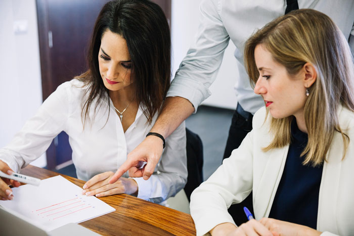 Three professionals discussing financial documents at a desk, illustrating a story about bankruptcy and penalties.