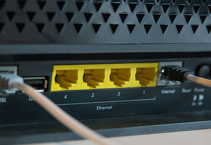 Close-up of an Ethernet router with connected cables demonstrating harmless but effective ways people got revenge on jerks.
