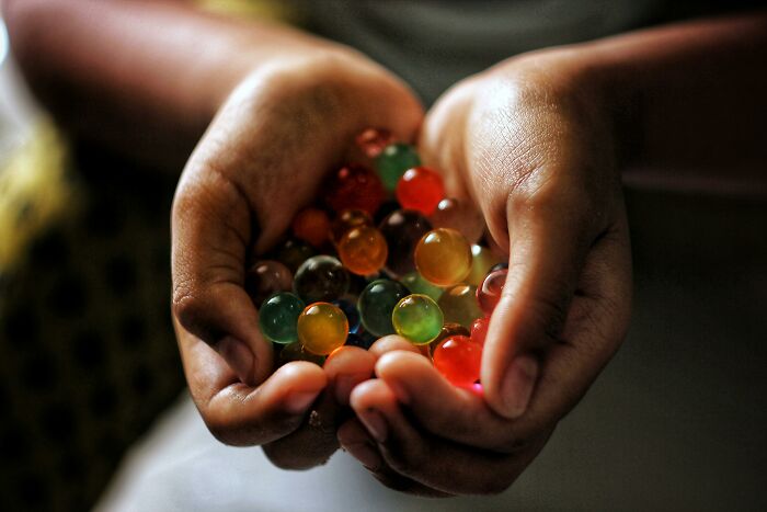 Close-up of hands holding colorful translucent marbles, symbolizing care and attention in healthcare workers' stories.