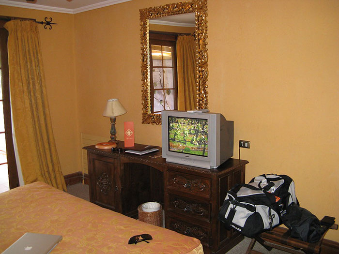 Cozy hotel room interior with classic wooden furniture and travel bags, highlighting tips for an elevated and stress-free hotel stay.