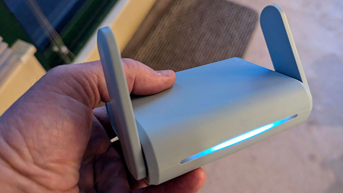 Hand holding a portable Wi-Fi router, a useful tip for a more elevated and stress-free hotel stay.