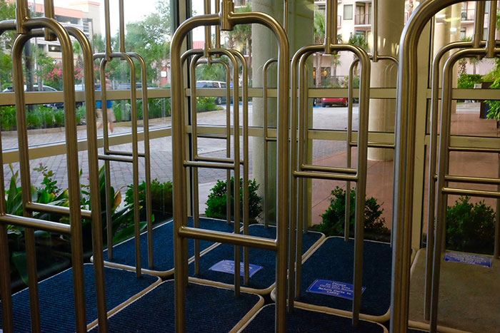 Hotel luggage carts lined up on blue mats near glass doors, enhancing a more elevated and stress-free stay at a hotel.