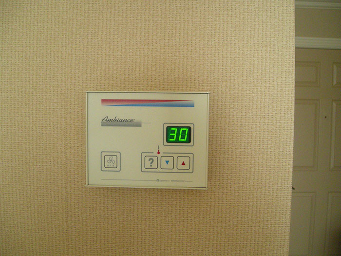 Hotel room thermostat set to 30 degrees with controls, illustrating tips for an elevated and stress-free hotel stay.