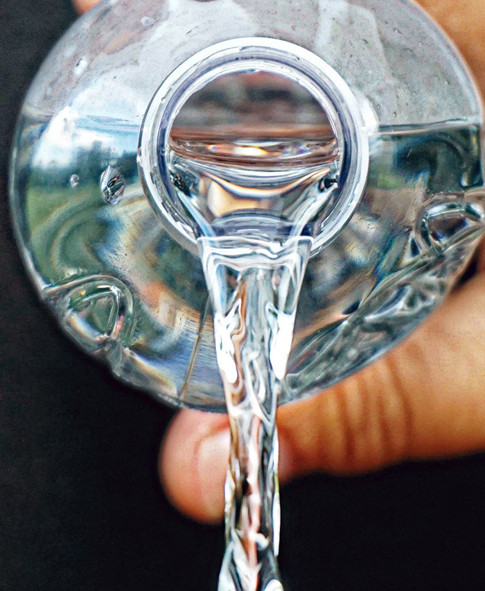 Close-up of clear water pouring from a bottle, illustrating tips to make a stay at a hotel more elevated and stress-free.
