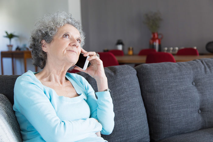 Older woman having a thoughtful phone conversation about a man&rsquo;s outburst over wife not liking mustard at home.