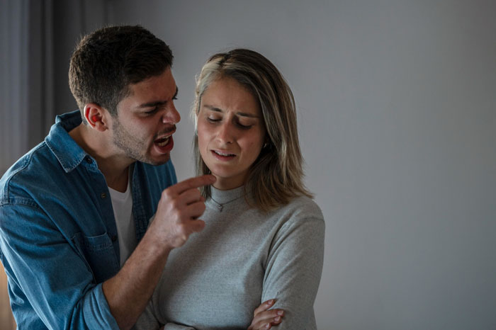 Man having outburst over wife not liking mustard, woman looking upset and uncomfortable during the argument indoors.
