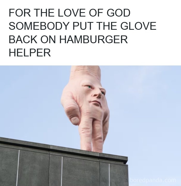 Giant surreal hand sculpture with a human face standing on a building, creating a confusing and unhinged visual effect.