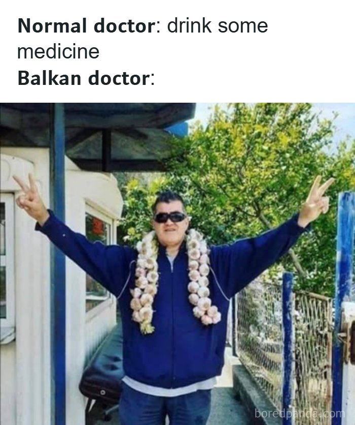 Man wearing garlic necklace and sunglasses with arms raised, capturing Eastern European memes relatable humor.