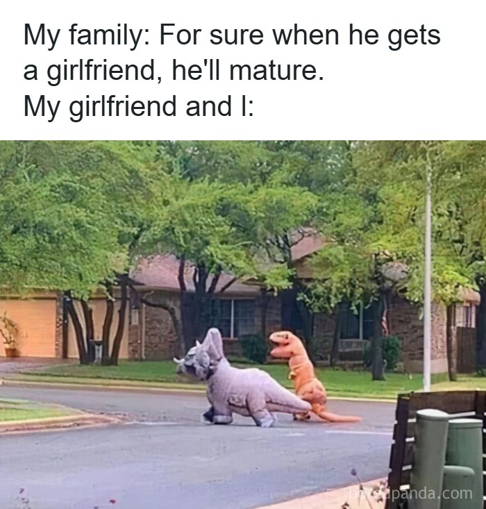Couple dressed in dinosaur costumes acting silly outside, illustrating funny romantic relationships memes humor.