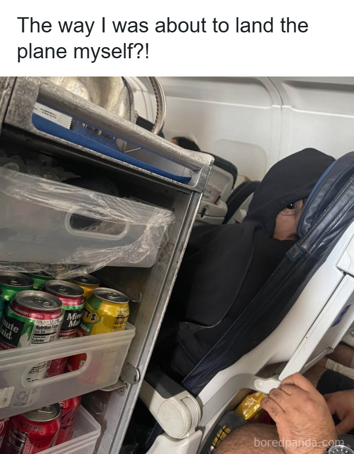 An unhinged pic of a passenger in a black hoodie peaking over an airline cart full of drinks, making the photo hilarious.