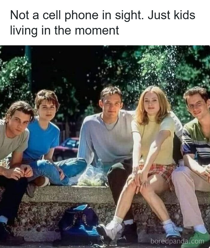 Group of ’90s kids sitting outdoors, enjoying the moment without cell phones, evoking ’90s memes and nostalgia.