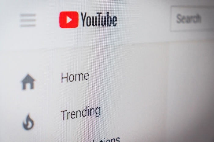 Close-up of YouTube homepage screen showing navigation menu, highlighting trends from 1960 to 2010 birth years.