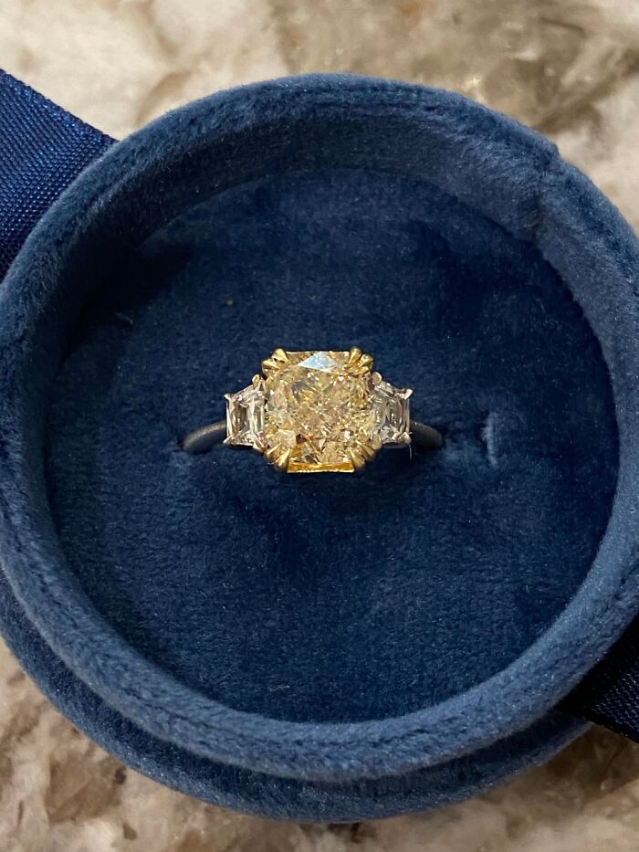 Gold and diamond ring with side stones in a blue velvet box, an unexpected find in elevator pits adventure stories.