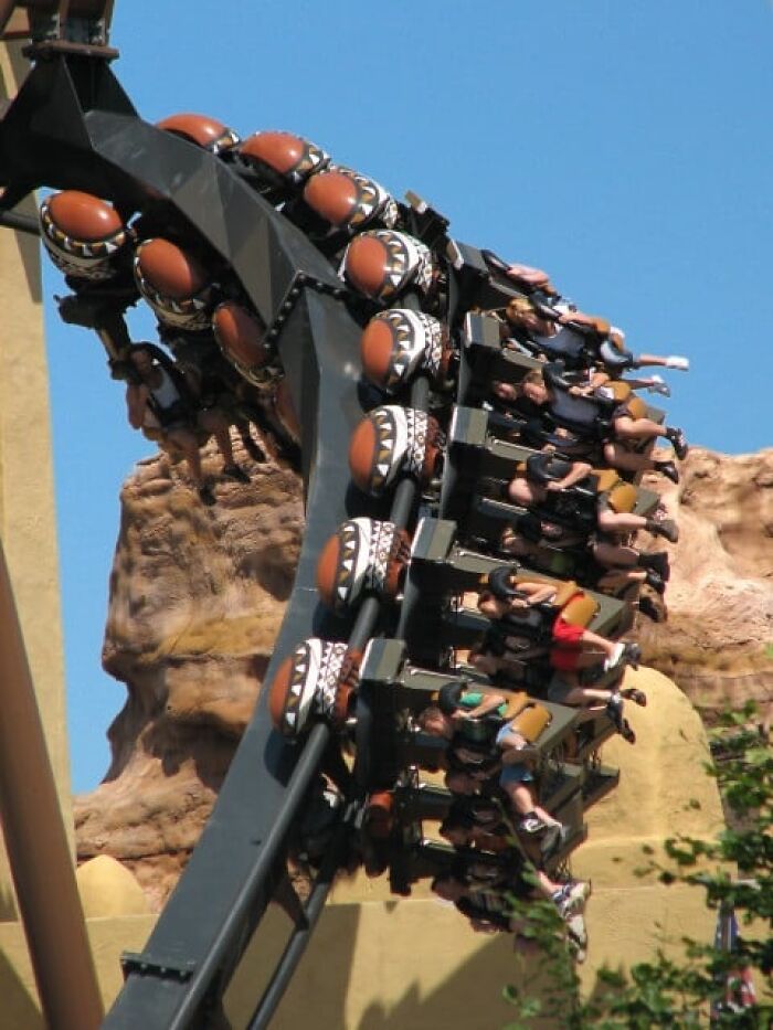 Roller coaster riders upside down on a thrilling loop, capturing moments that still feels fake but are 100 percent real.