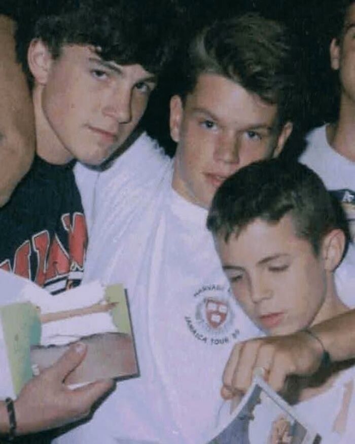 Three teenage boys looking at photographs