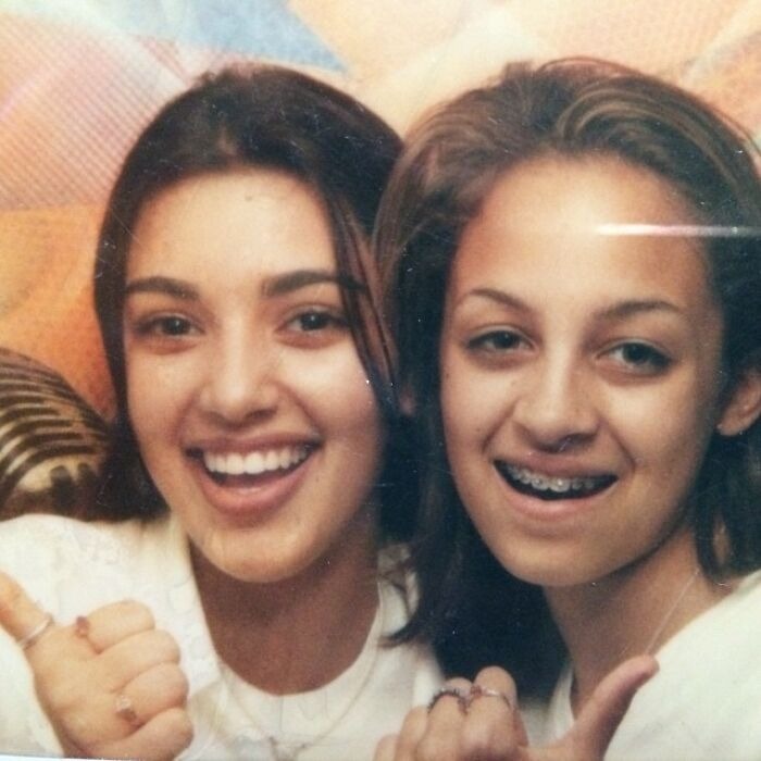 Two young girls smiling and giving thumbs up for celebrity friendships