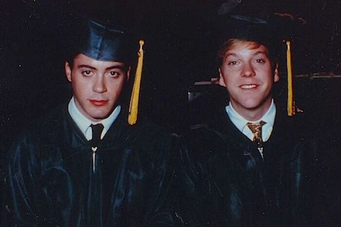 Two men in graduation caps and gowns from celebrity friendships
