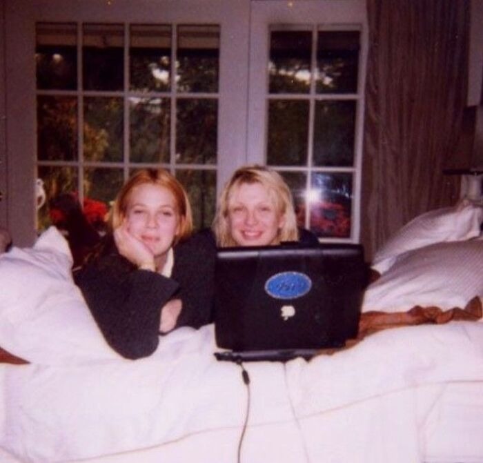 Two women using a laptop together representing celebrity friendships