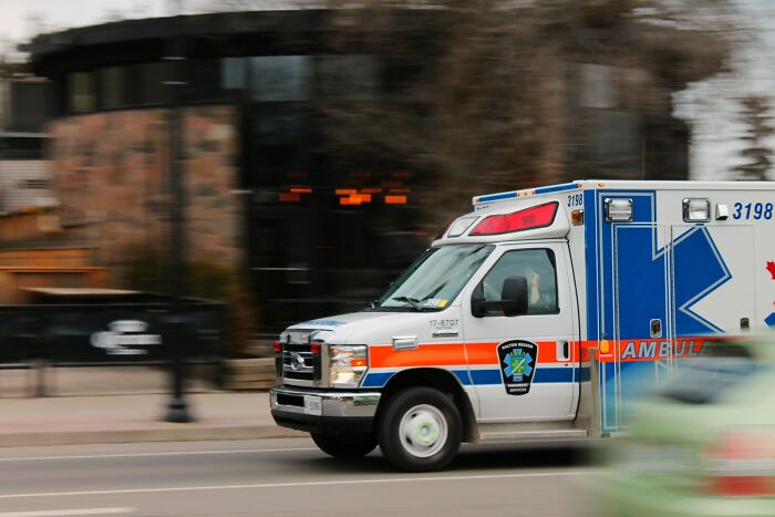 Ambulance rushing down a city street with motion blur, representing sudden urgent situations and people who rage quit their jobs.