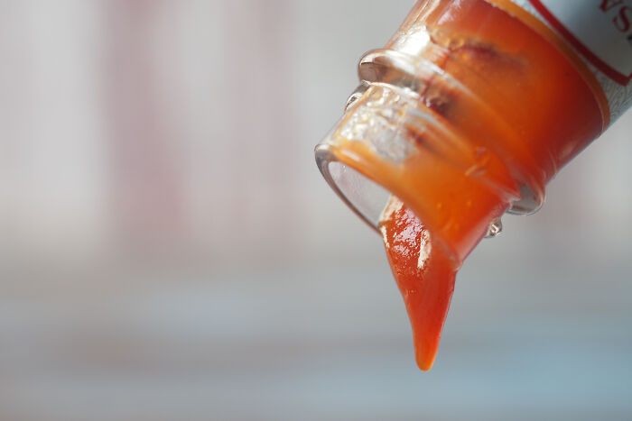 Close-up of ketchup bottle pouring sauce, illustrating rude customers who learned the hard way not to mess with staff.