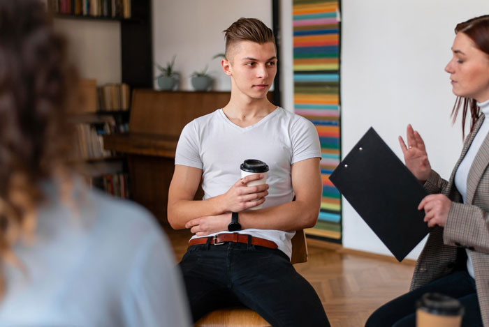 Teenager holding coffee cup in a casual meeting with a woman, depicting kid work and mother fired situation discussion. Teenager holding coffee cup in a casual meeting with a woman, depicting kid work and mother fired situation discussion.