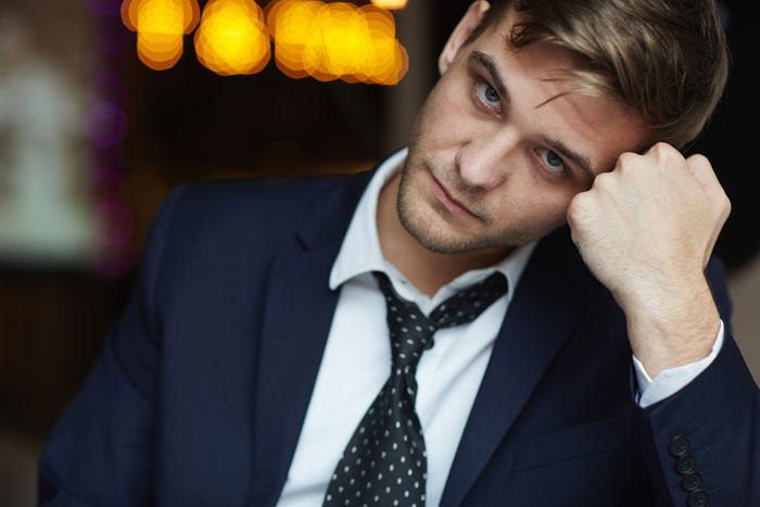 Young man in suit looking stressed and tired, representing challenges of kid work mother fired situations in professional life. Young man in suit looking stressed and tired, representing challenges of kid work mother fired situations in professional life.