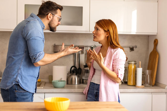 Man and woman arguing in kitchen about cabinets, man frustrated and wife livid over supergluing rubber on cabinets.