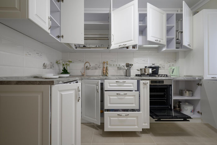 Modern kitchen with multiple open cabinets and drawers, showing details of cabinet doors and storage spaces.