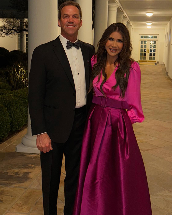 Bryon and Kristi Noem dressed formally at an event, linked to $2.6 million debt scandal and luxury spending questions.