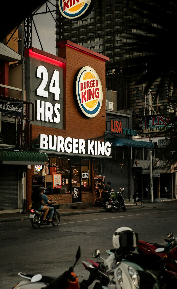 A Burger King restaurant with a 24 HRS sign and neon lighting at dusk. The image hints at people who rage quit their jobs.