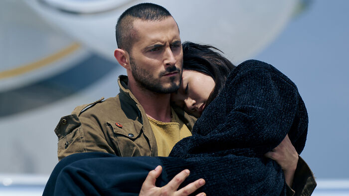 Actor from The Boys holding a woman, scene hinting at controversial army history sparking fans' call for boycott. Actor from The Boys holding a woman, scene hinting at controversial army history sparking fans' call for boycott.