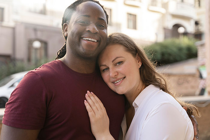 A happy couple, woman leaning on man's shoulder, smiling warmly. A controlling MIL would struggle with this harmony.