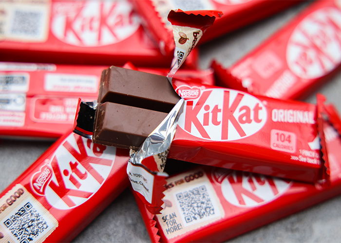 Several KitKat chocolate bars, one partially unwrapped, highlighting the stolen KitKat tracker campaign by the brand.