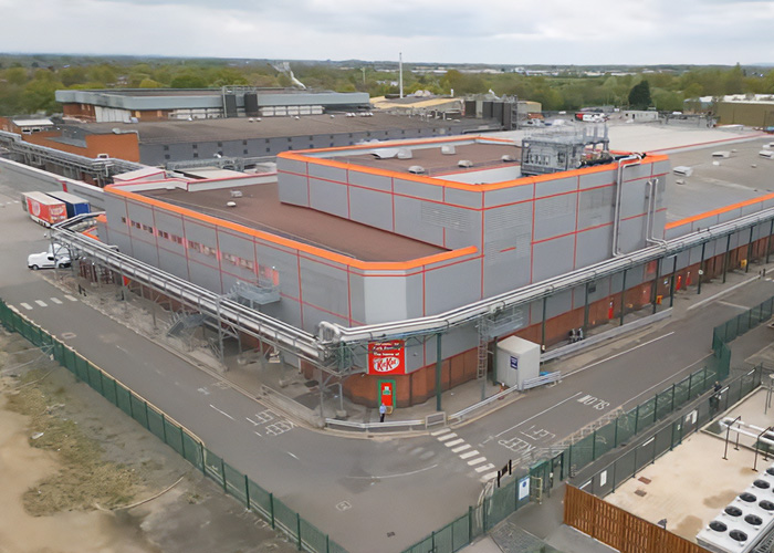 KitKat factory exterior with trucks and loading docks, related to stolen KitKat tracker and public help campaign.