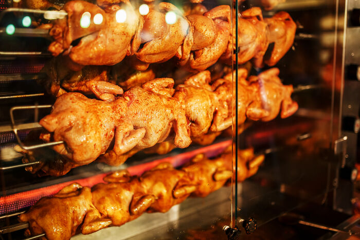 Golden rotisserie chickens cooking on spits behind glass. Discover the wildest reasons employers had to fire someone.