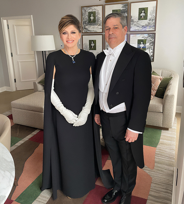 A couple in formal attire, the woman in a black cape dress and white gloves. Looks from MAGA figures.