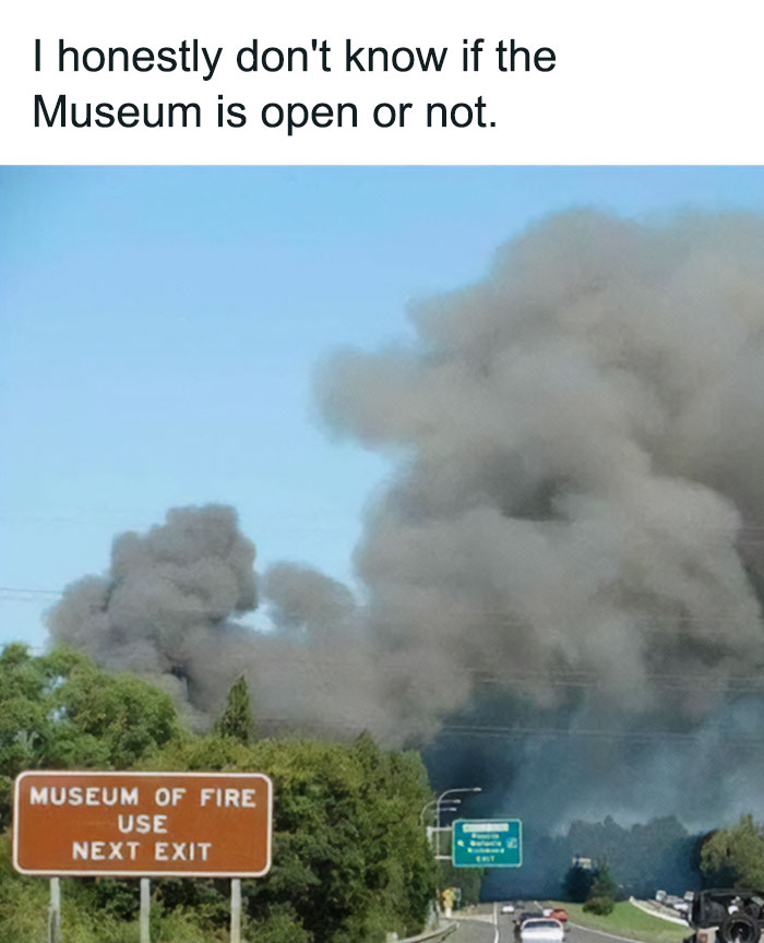 Highway scene with heavy smoke and a Museum of Fire sign, humorously questioning if the museum is open, safe-for-work meme.
