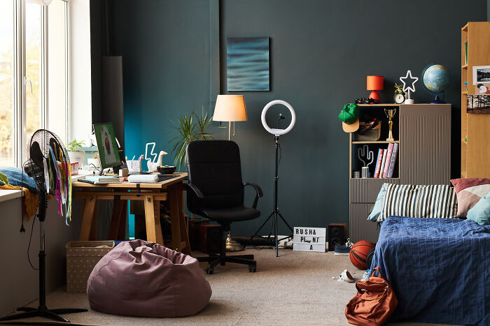 A messy bedroom with a desk, ring light, and bed. It's a relatable image for stories about finding out you were being cheated on.