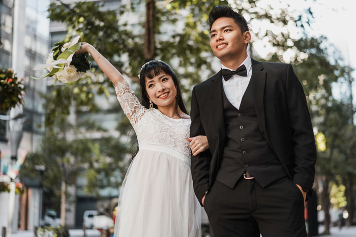 Young couple dressed in wedding attire outdoors, illustrating issues with toxic MIL visits and housing disputes.
