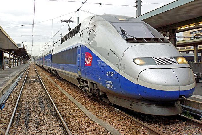 High-speed train at a station representing historical mistakes with massive consequences in transportation development.