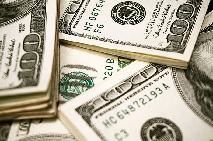 Stacks of hundred-dollar bills close-up, representing costly historical mistakes with massive financial consequences.