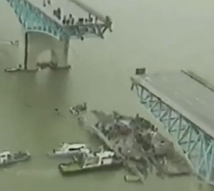 Collapsed bridge over water with rescue boats below depicting historical mistakes with massive consequences.