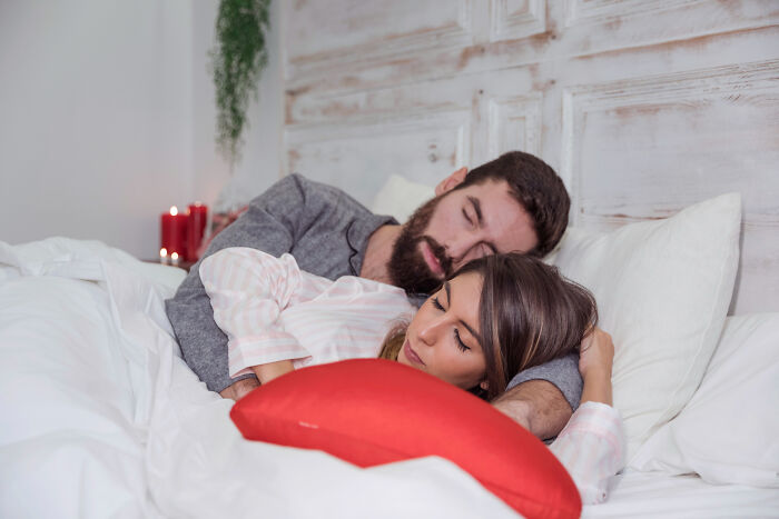 A couple sleeping peacefully in bed, with a man embracing a woman, showing the impact of diagnosed narcissists.